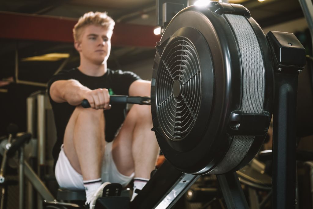 Man training on a rowing machine, demonstrating proper form — which rowing machine is best for home workouts?